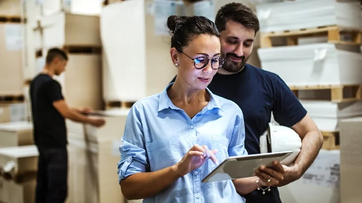 photo of woman and a man looking at a tablet